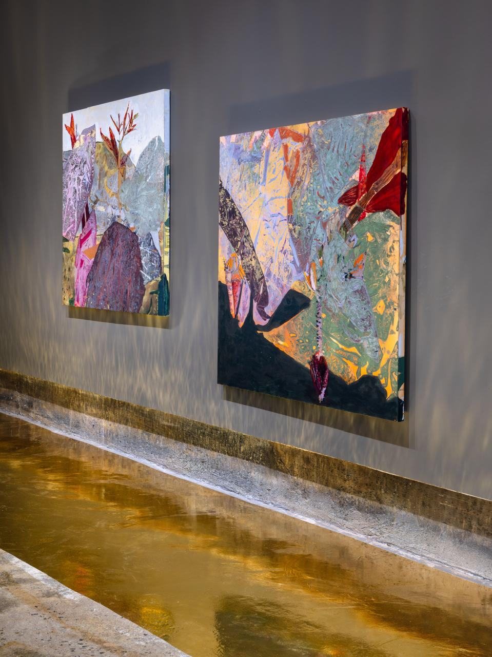 Duas pinturas da mostra SOL lado a lado, com reflexo no piso metálico.
