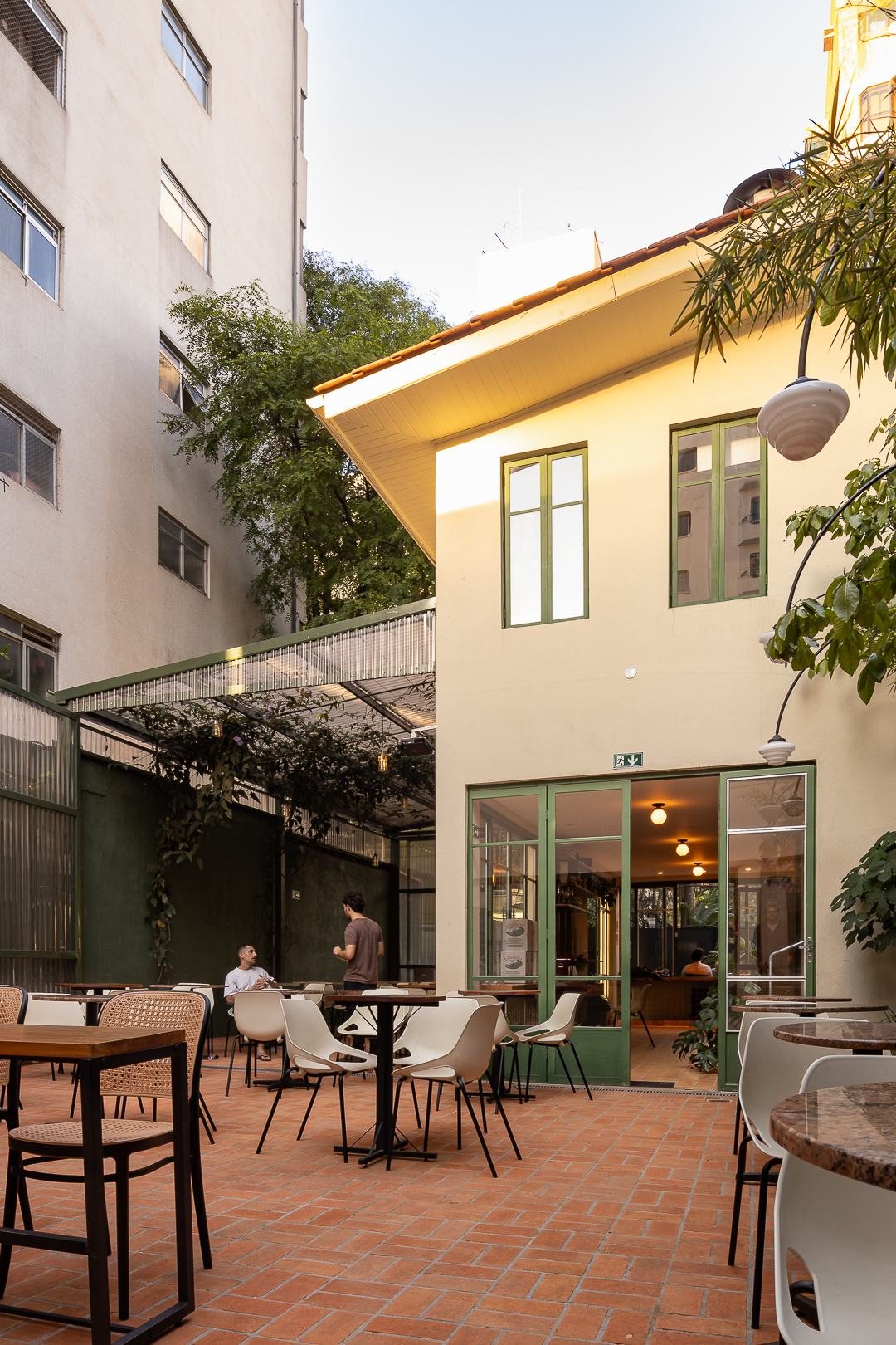 Pátio da Vinícola Urbana com mesas, cadeiras e pergolado verde